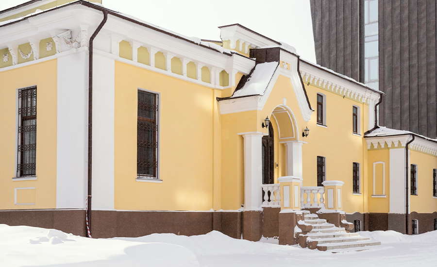 Stucco installation during winter using heated enclosures and protective covers in a cold construction site.