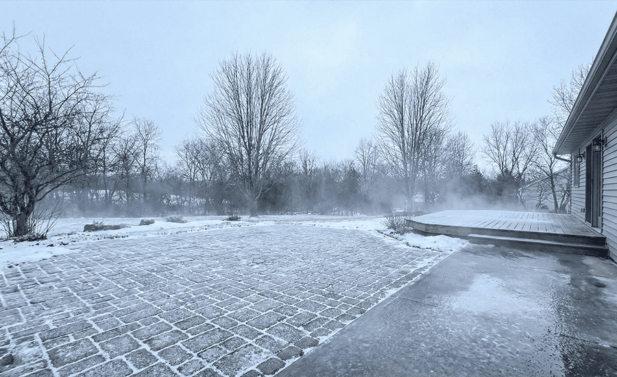 Driveway and patio surface in winter with ice buildup and snowfall showing conditions before safe pressure washing