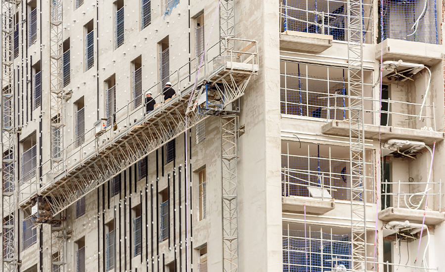Workers performing façade repair on a high-rise building using suspended scaffolding in New York City