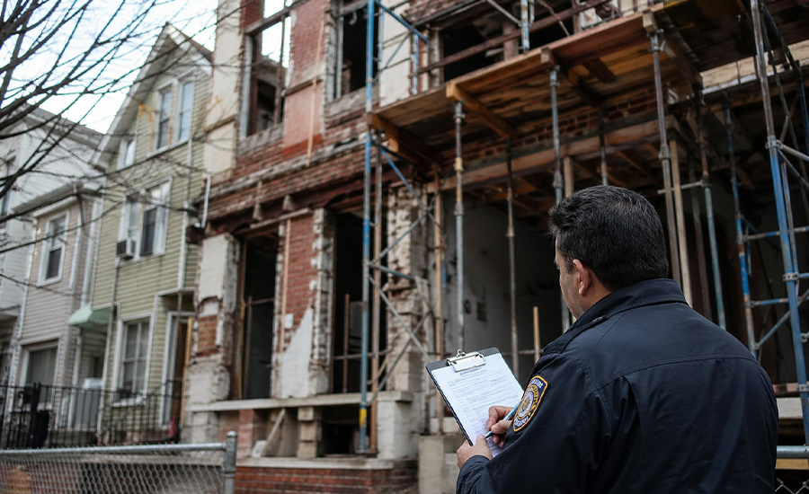 NYC building violations with damaged facade and inspection in progress