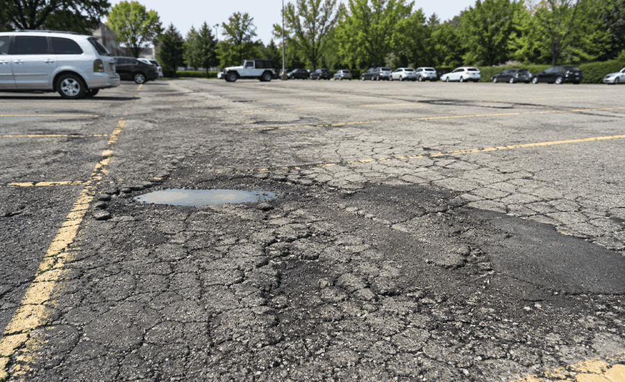 Parking lot repaving in NYC with asphalt paving crew showing signs of surface repair and maintenance needs