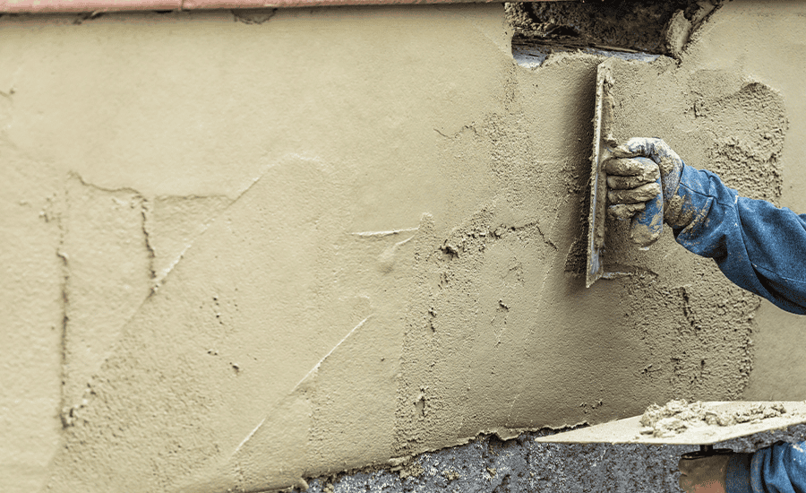 Stucco wall with visible cracks being repaired on a residential building in NYC