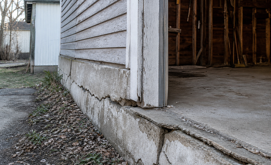 Older NYC garage with cracked foundation walls and damaged concrete caused by soil movement and water pressure