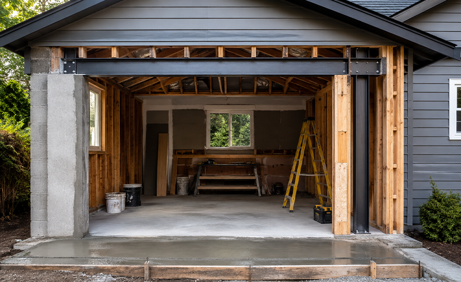Restored residential garage with clean concrete floor and drainage system after structural repair