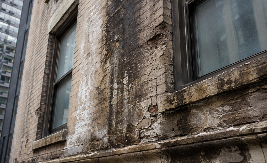 Water penetration damage on NYC building façade with moisture stains, cracked masonry, and exterior wall deterioration