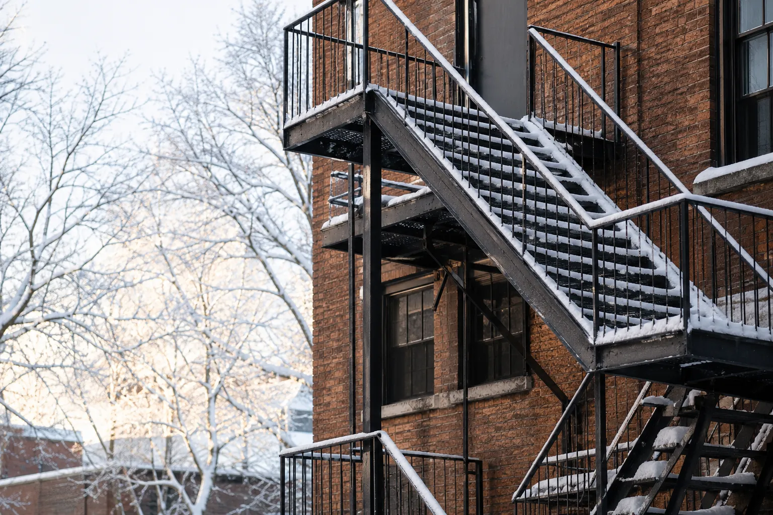 Snow-covered fire escape on a brick building during winter in New York City Snow-covered fire escape on a brick building during winter in New York City